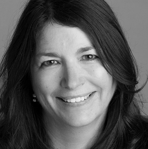 Grayscale portrait of smiling woman with dark hair and eyes.